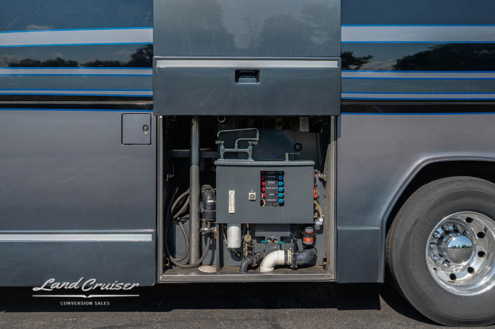 Closeup of the central electrical bay with visible fuse panel and wiring next to rear wheel well.