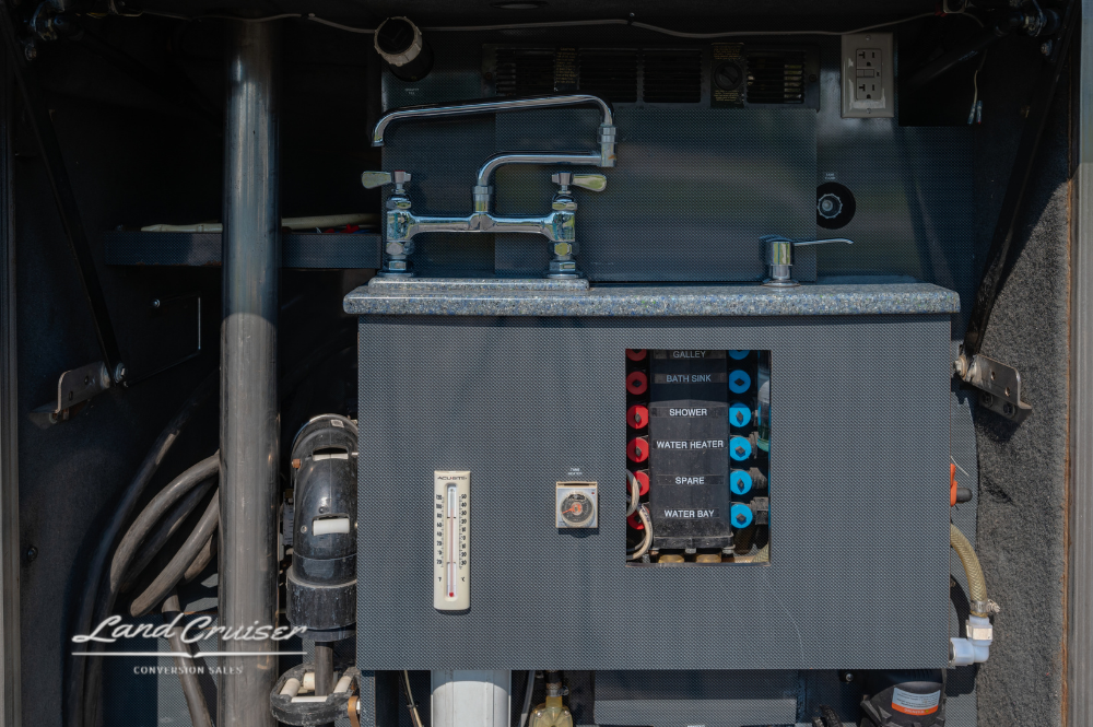 Straight-on view of the coach’s main electrical distribution panel with labeled switches and outlets.