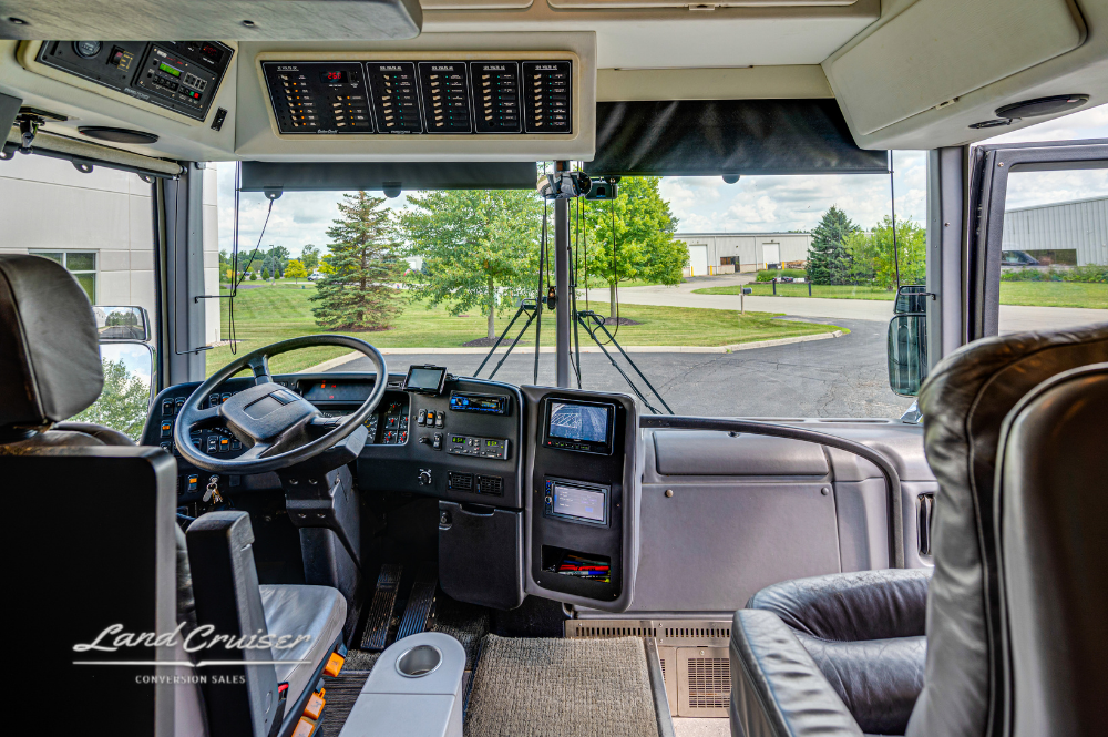 Full cockpit and dashboard view inside Prevost XLII motorhome with leather driver and copilot seats