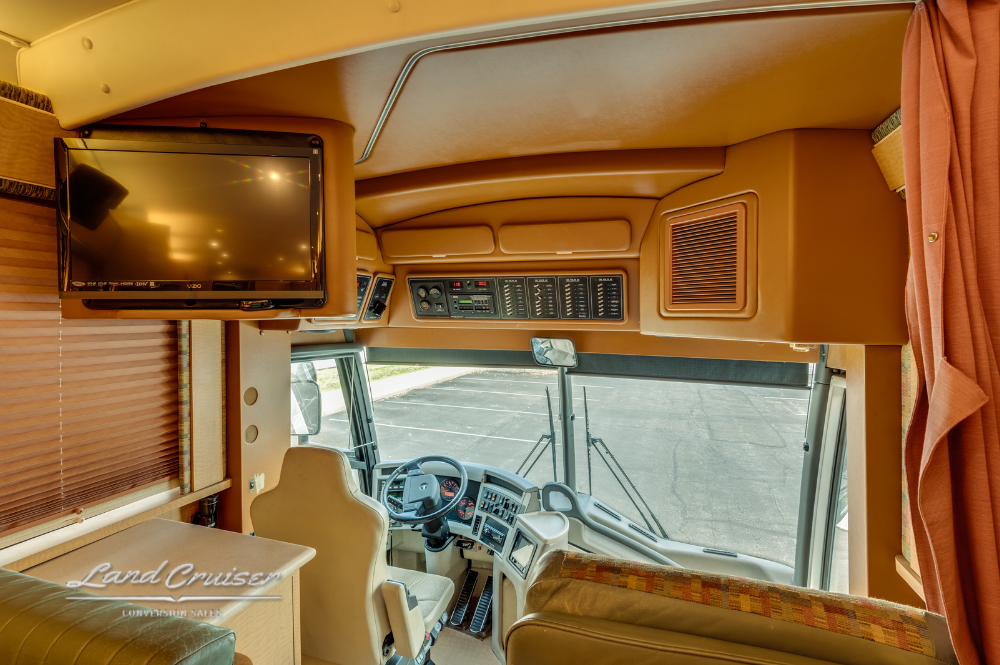 Front lounge area with leather seating and dinette in MCI motorhome