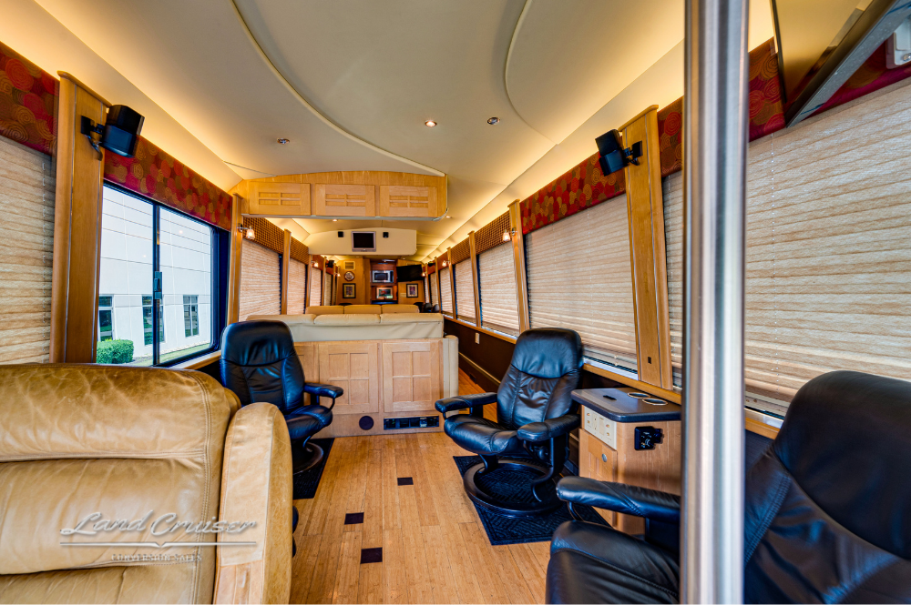 Wide front lounge view with custom leather seating, wood cabinetry, and modern curved ceiling design