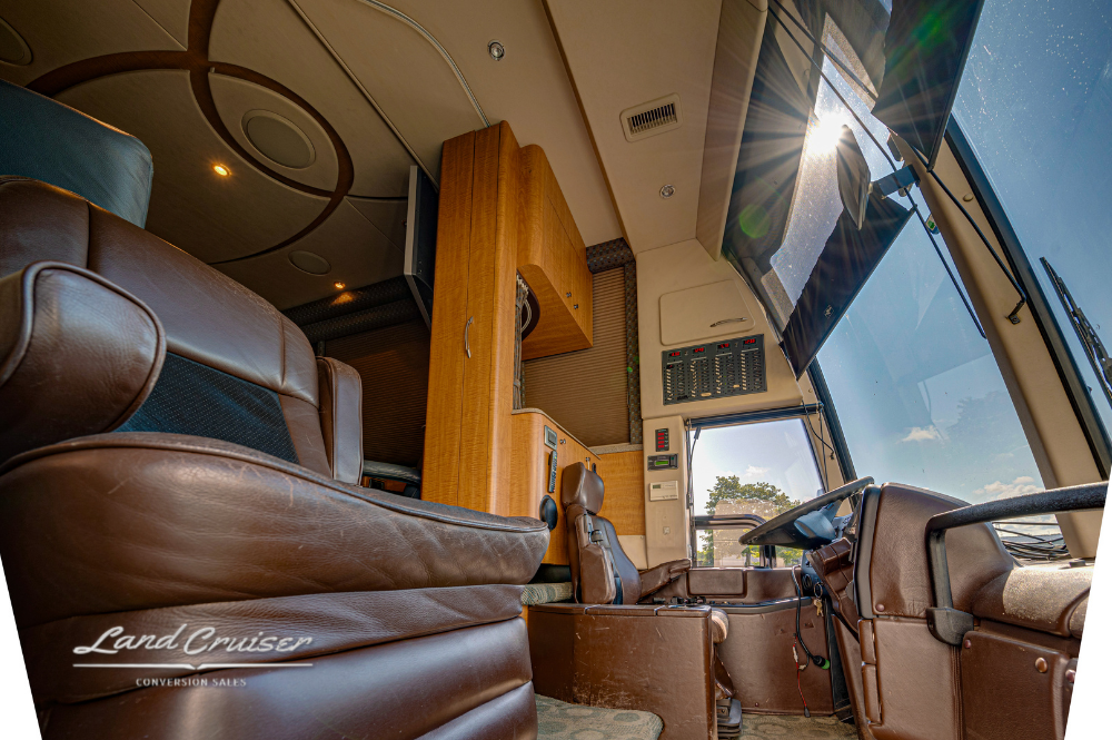 Panoramic view from front lounge looking forward to the cockpit, highlighting wood cabinetry and trim.