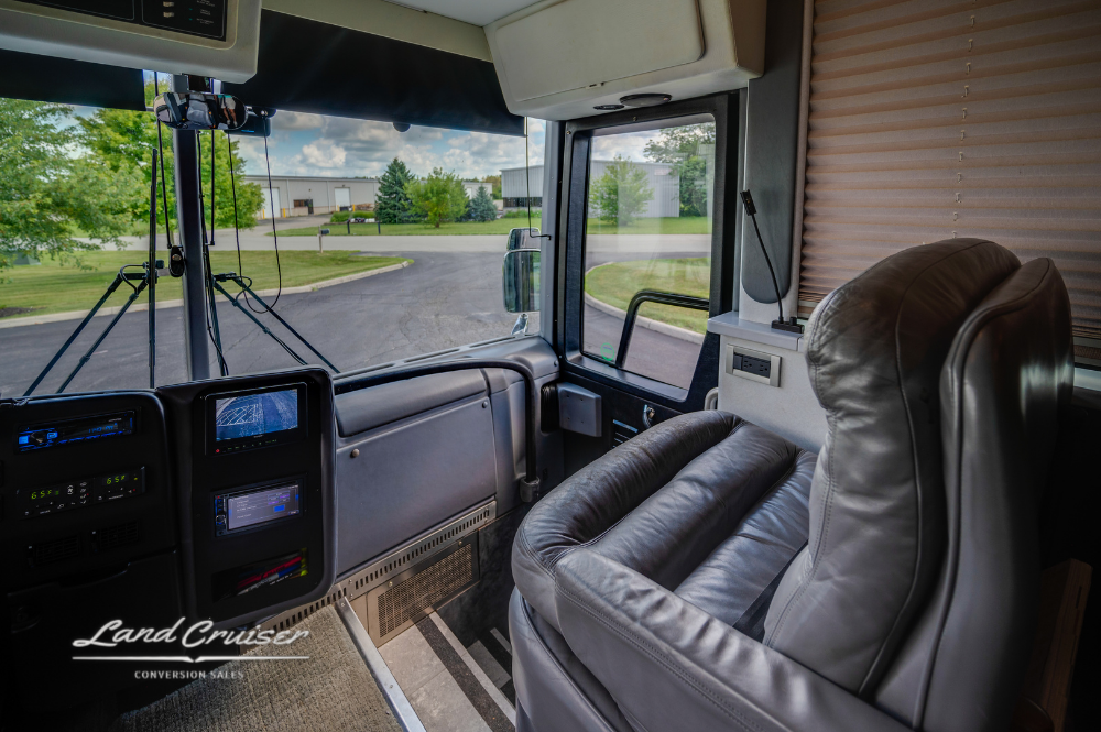 Front cockpit seating with copilot recliner and panoramic windshield inside VIP Custom Coach