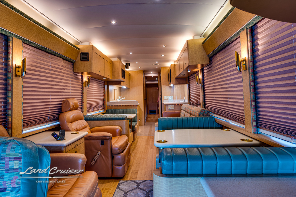 Rear lounge of MCI motorhome with sleeper sofas and overhead storage