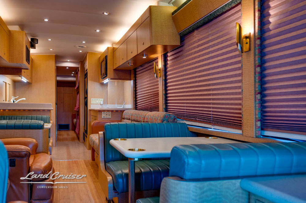 Dining area with dual dinettes upholstered in leather inside MCI motorhome