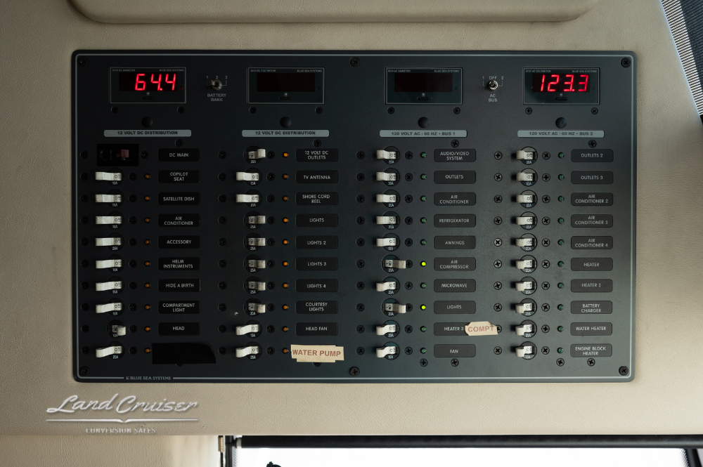 Close-up of power control panel with labeled switches, battery readouts, and status indicators.