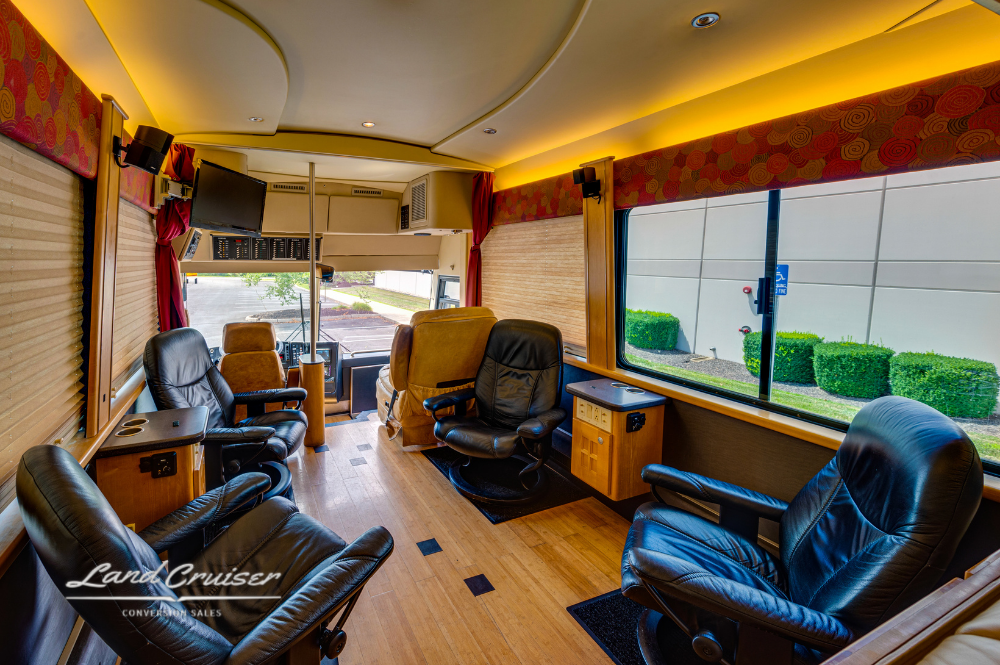 Main salon view with custom black leather chairs, bamboo floor, and wood-paneled walls