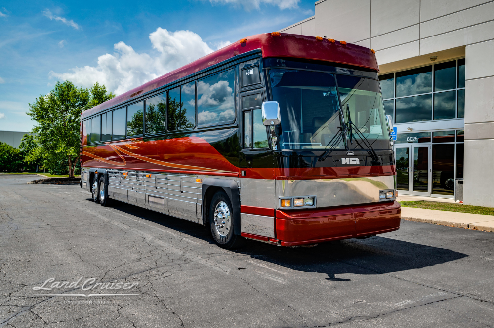 Front driver-side view of 2001 MCI bus with aerodynamic design and bold red graphics