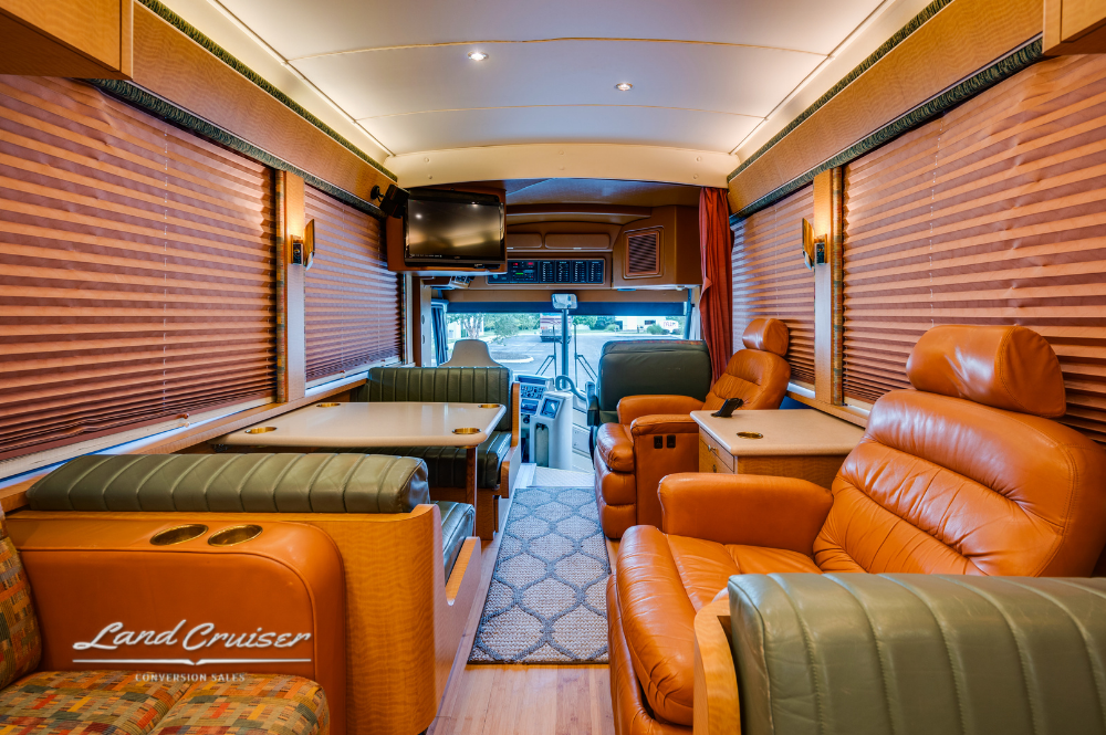 Side lounge with sofa seating and table in MCI 102EL3 motorhome