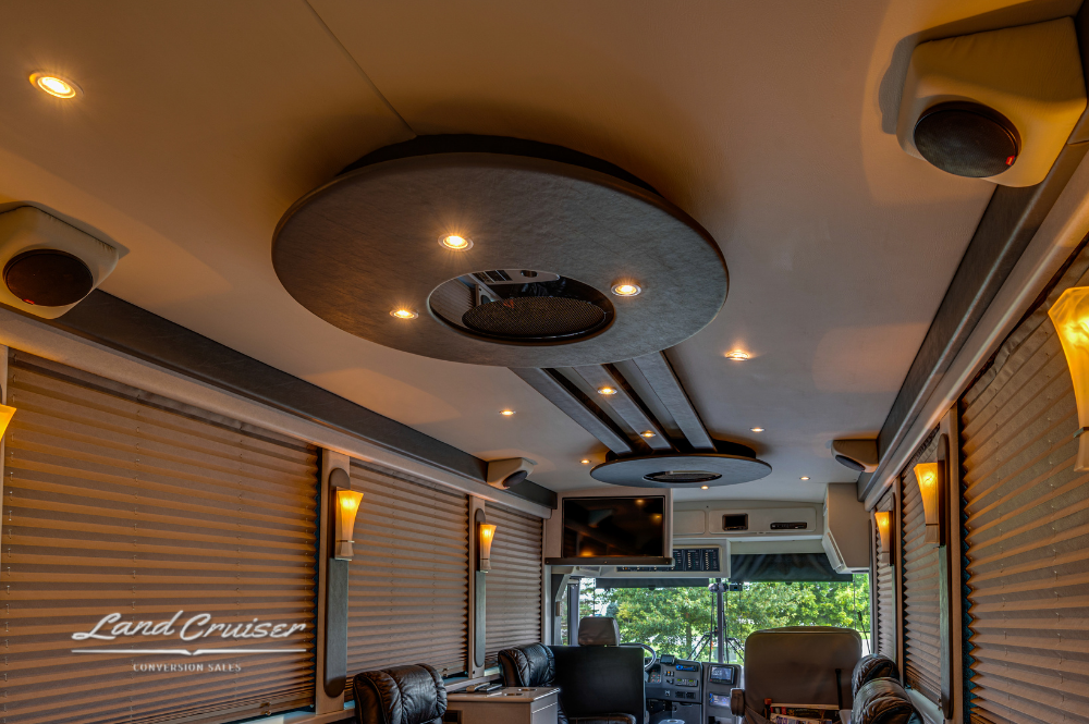 Ceiling design detail with integrated lighting and speaker system inside luxury motorcoach lounge