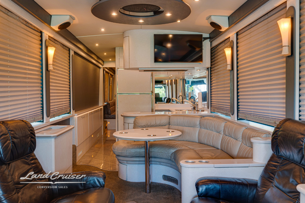 Forward salon and galley transition with large sofa, flatscreen TV, and upscale cabinetry