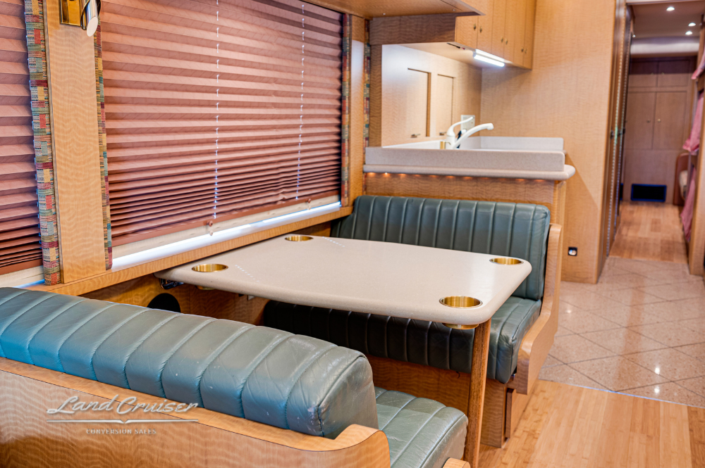 Dinette and sofa arrangement with overhead cabinets inside motorhome
