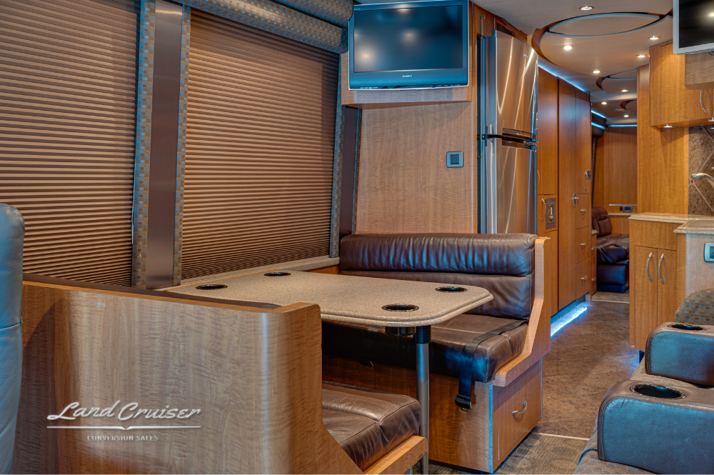 Dining area with leather booth seating and mounted TV in front salon.
