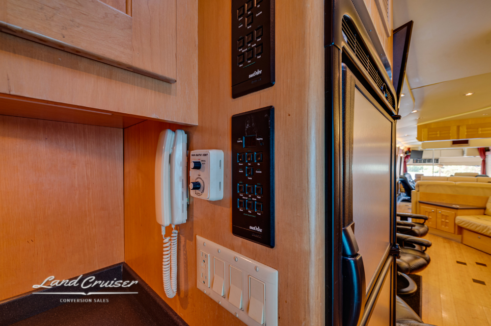 Close-up of galley control panels, light switches, and mounted intercom system