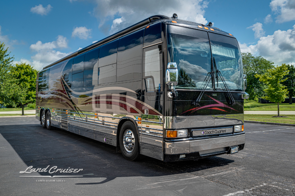 Passenger-side angle showcasing non-slide Prevost XLII bus conversion with metallic and maroon accents