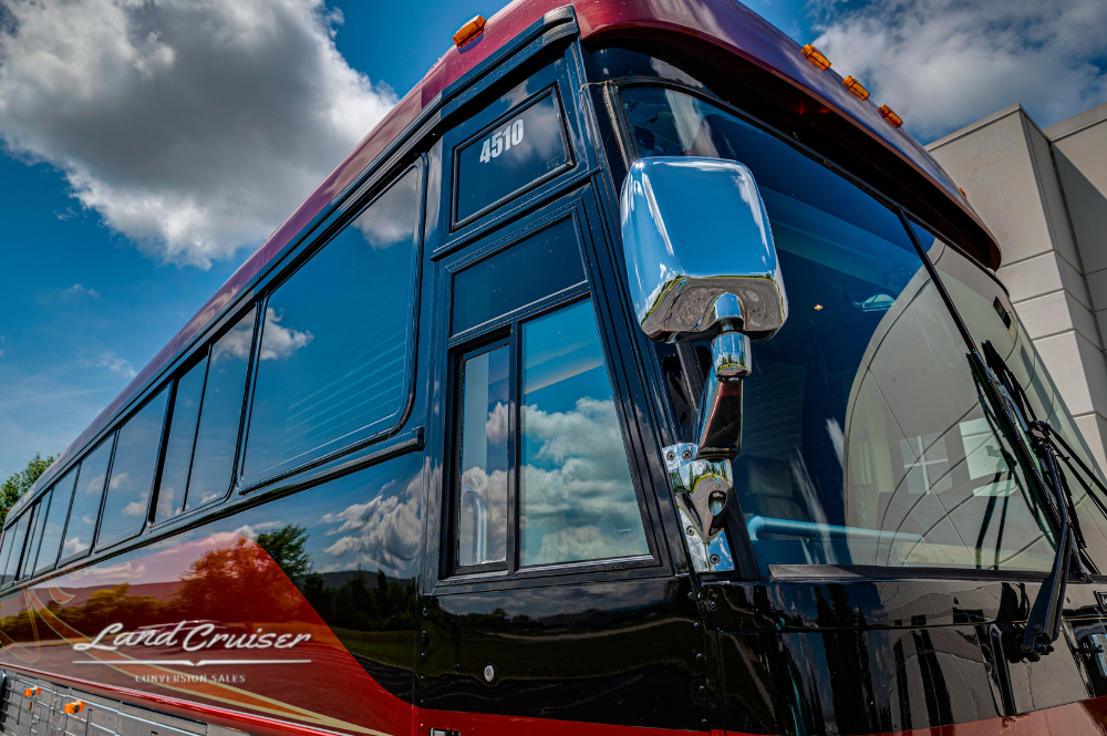 Close-up of front corner and mirrors on Churchill executive coach reflecting blue sky and clouds