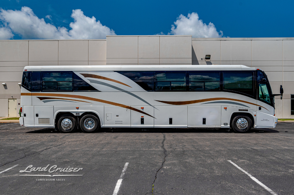 Full passenger-side view of 45-foot MCI 102EL3 parked outdoors