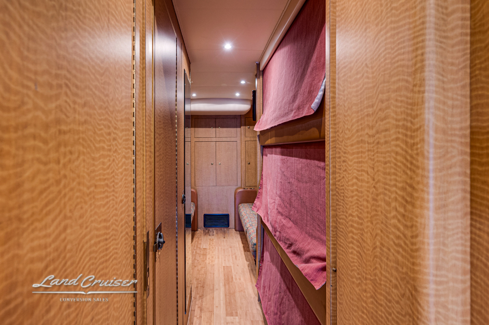 Hallway with bunks and privacy curtains inside MCI 102EL3