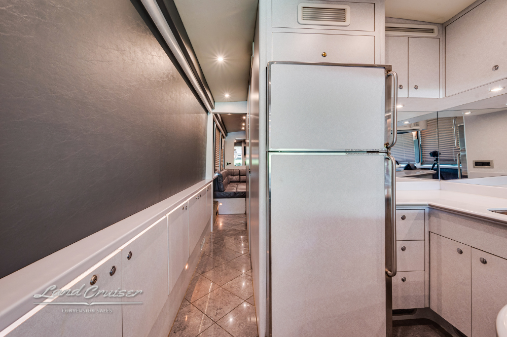 Rear view of motorcoach galley showcasing full-size refrigerator and extensive counter space