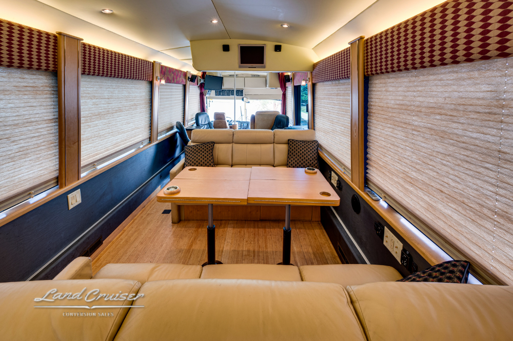 Dining area with dual booth seating, solid wood table, and full-length window blinds