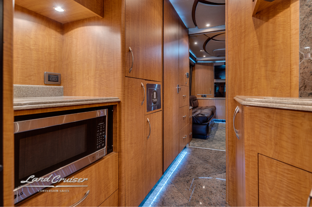 Hallway view with microwave, cabinetry, and under-cabinet LED accent lighting.