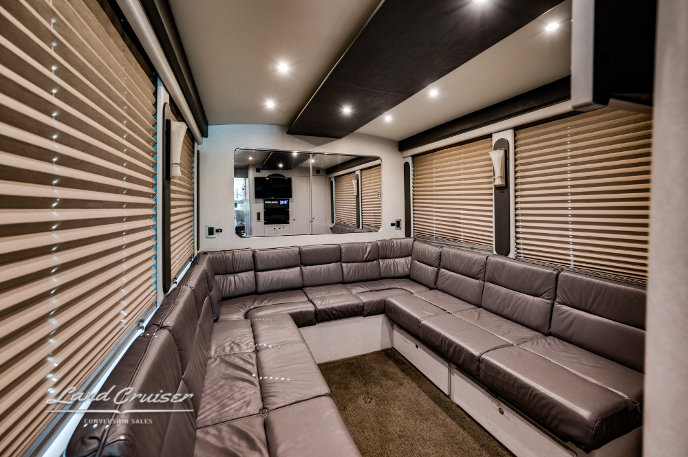 Rear lounge with full-length leather sectional sofa and blackout blinds in bunkless layout