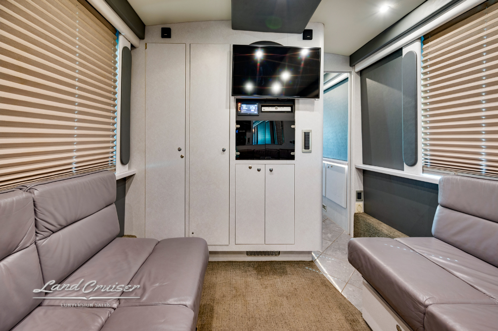 Entertainment console and storage cabinetry in rear salon area of luxury tour bus