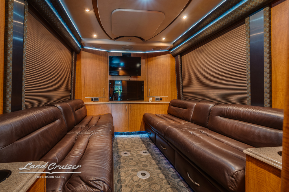 Executive lounge area with dual leather sofas, accent lighting, and media console.