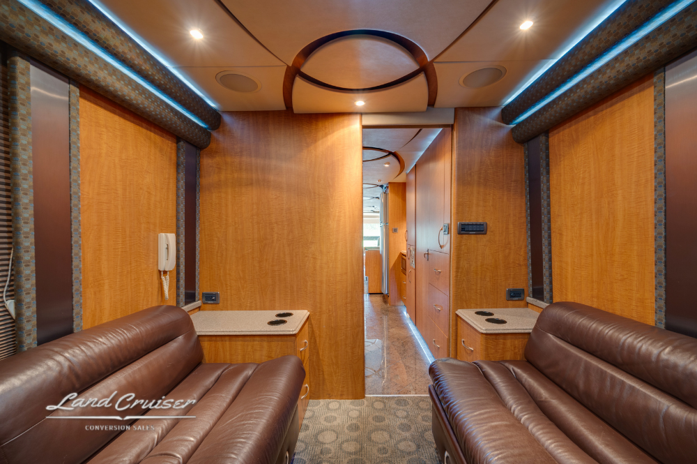 Private rear lounge with dual leather couches and closed privacy doors.
