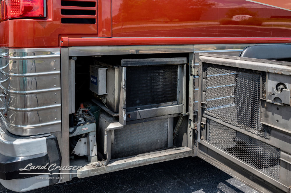 Open utility compartments revealing generator and electrical components on driver's side