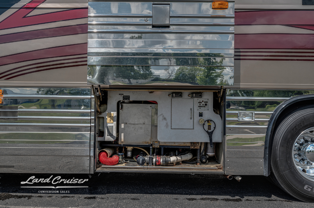 Compact utility compartment on midsection of Prevost XLII motorhome conversion with plumbing access
