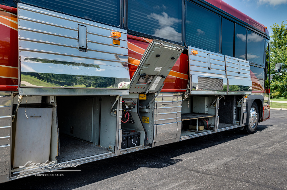 Storage bays open on passenger side of Churchill coach showing multiple custom compartments