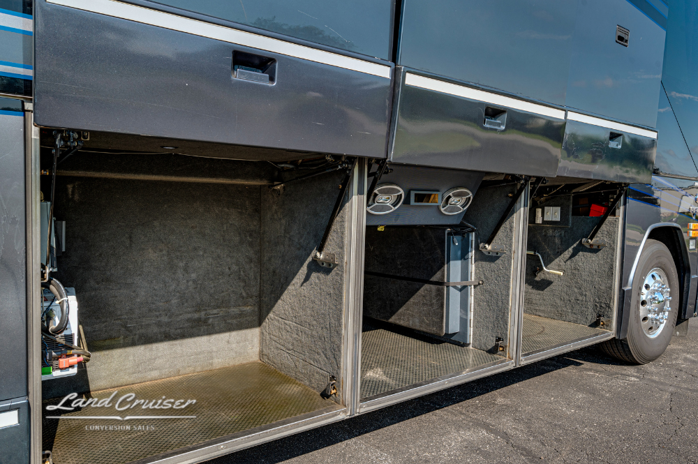 Passenger-side luggage bays opened to reveal spacious compartments with mounted speakers and lighting.