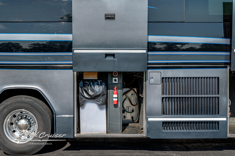 Curbside exterior utility bay with trash bin, fire extinguisher, and electrical compartment exposed.
