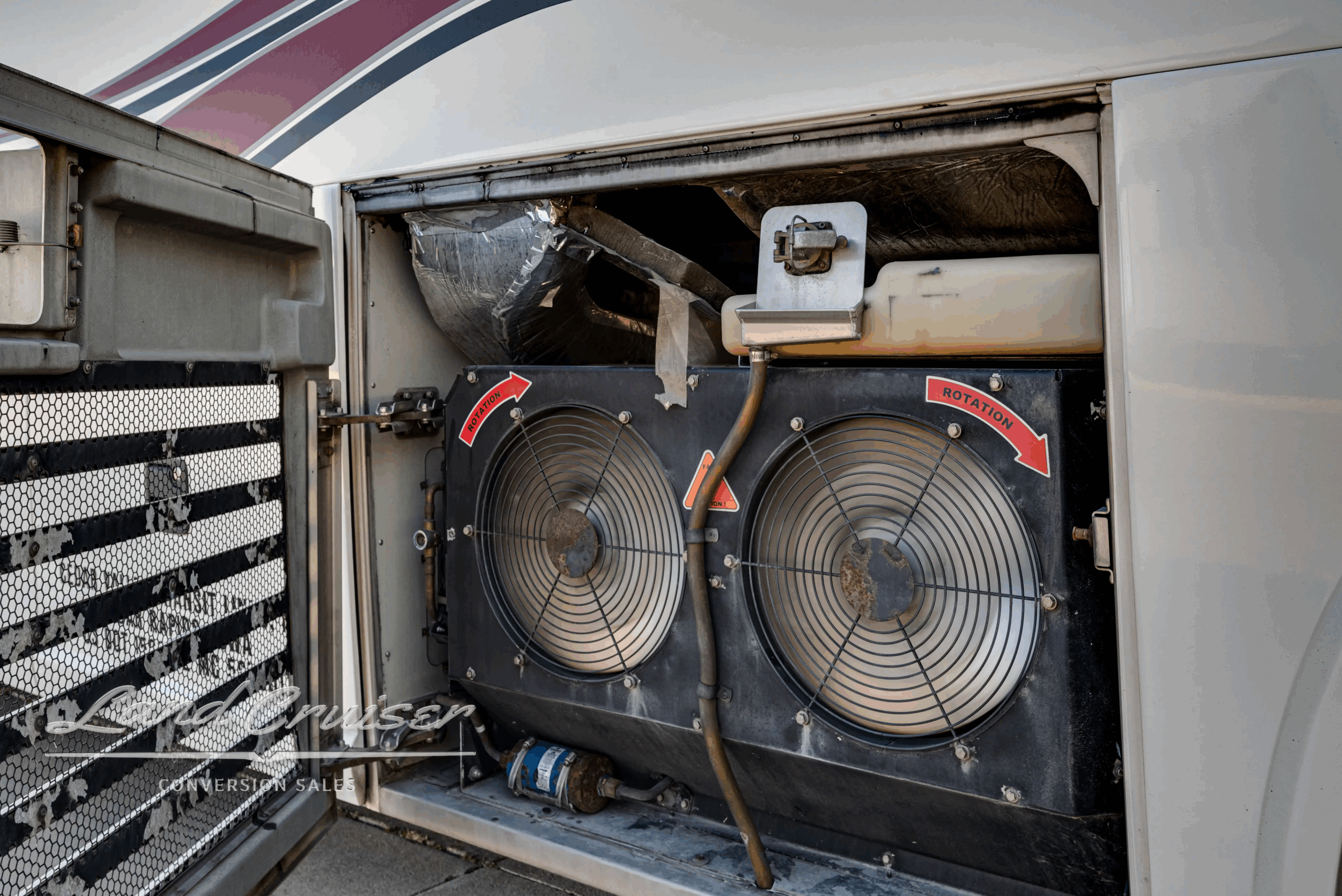 Dual HVAC condenser fans in curb-side equipment bay.