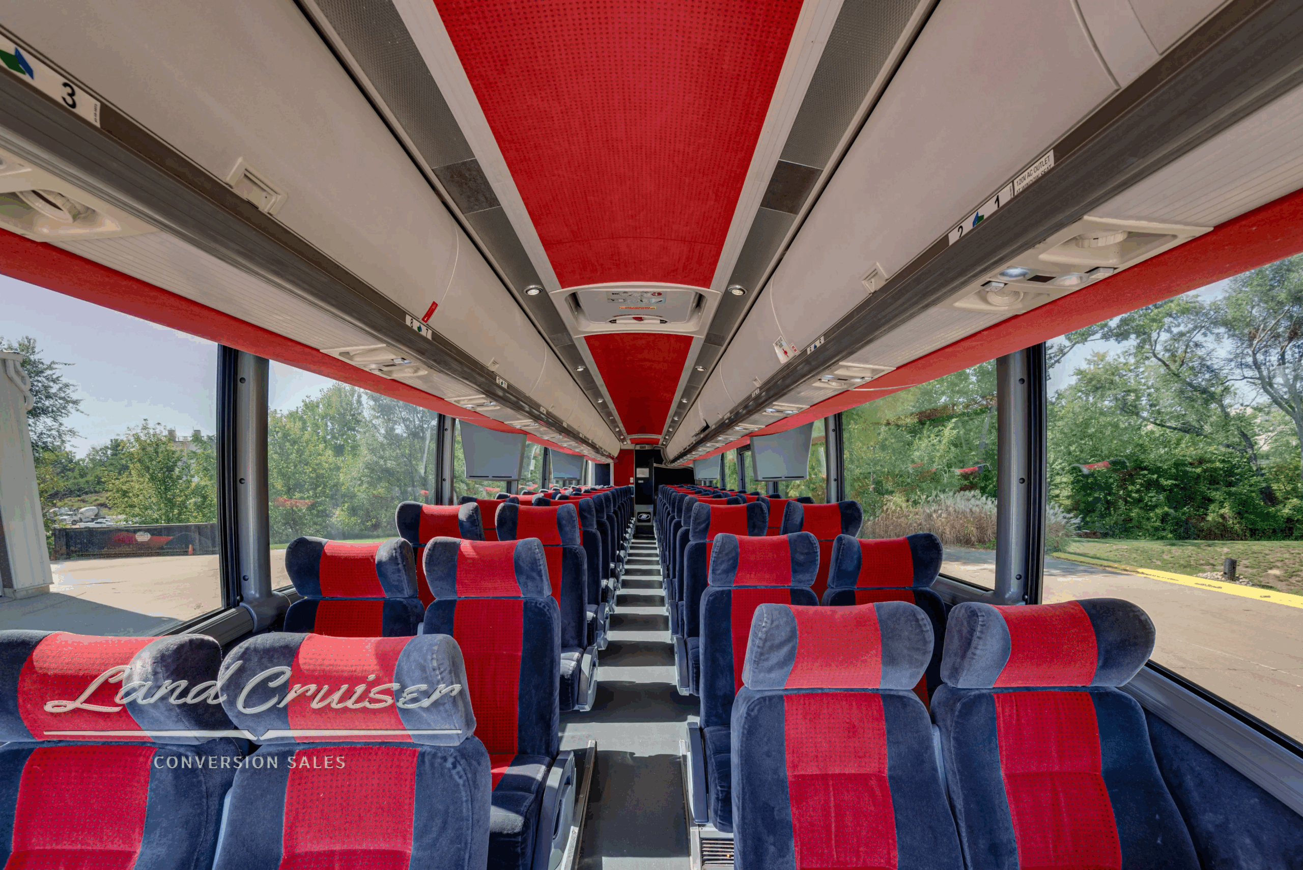 Interior aisle looking forward with overhead racks and lighting.