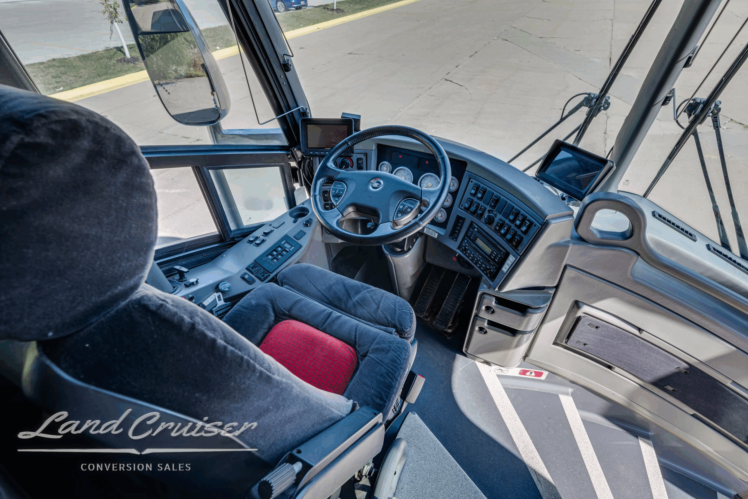 Driver cockpit with steering wheel, gauges, and controls.