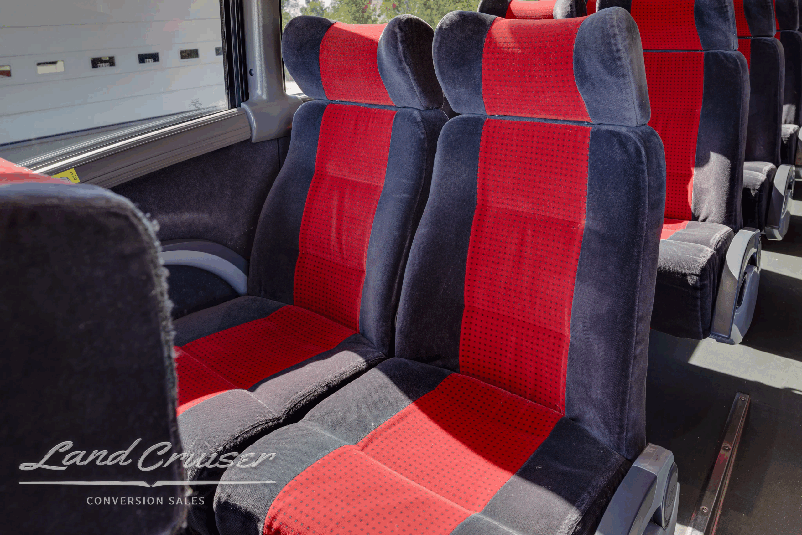 Close-up of red and gray fabric seats with armrests.