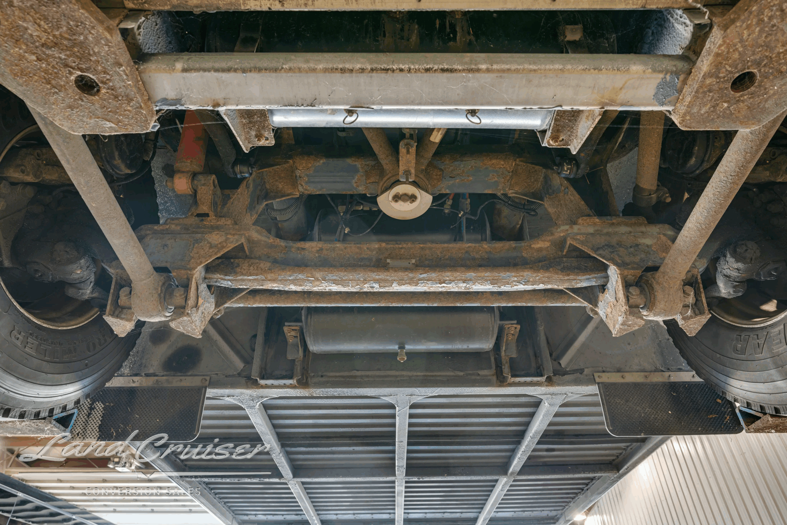 Rear undercarriage with protective grille beneath engine area.