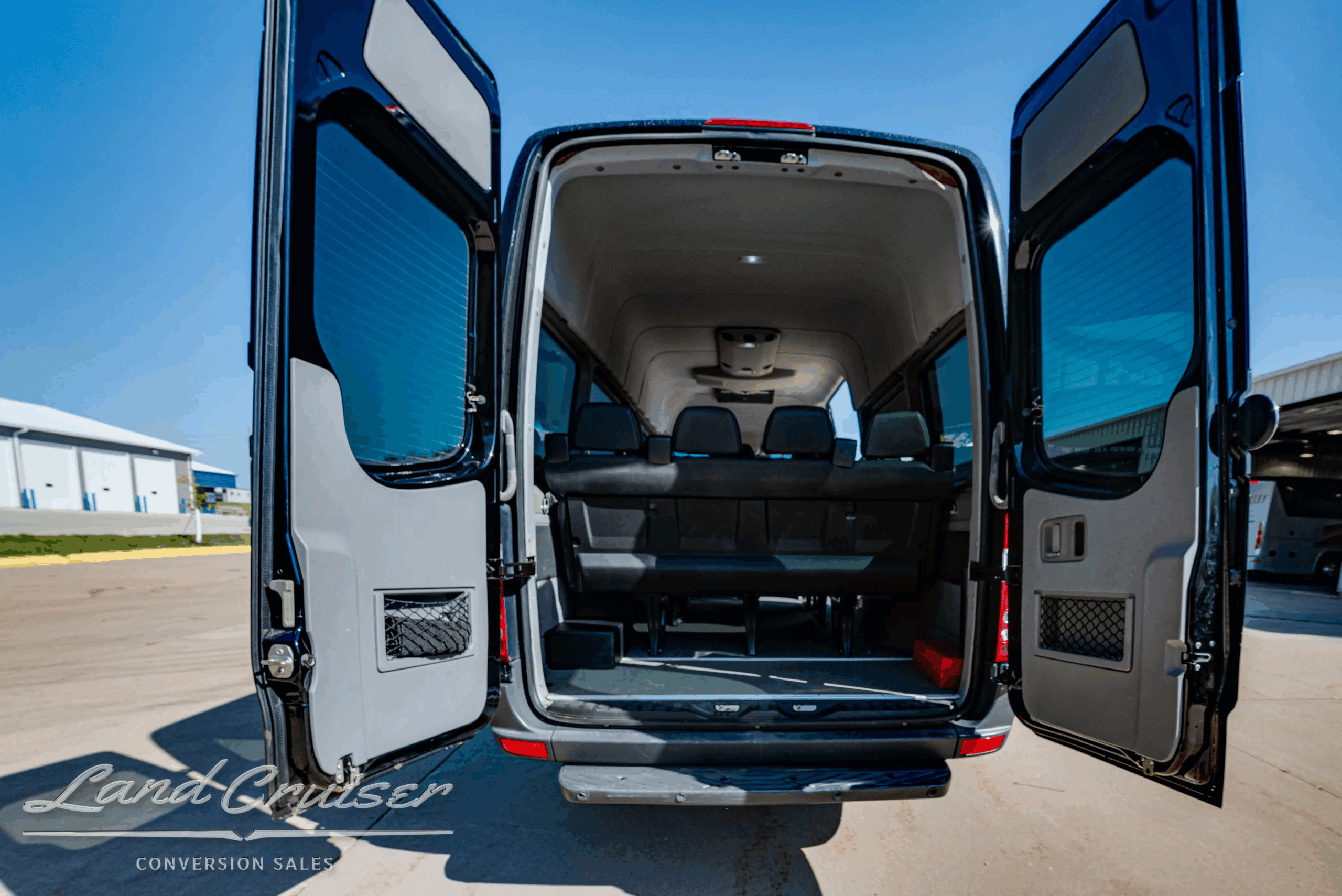 Rear cargo doors open revealing rear seating and luggage area.