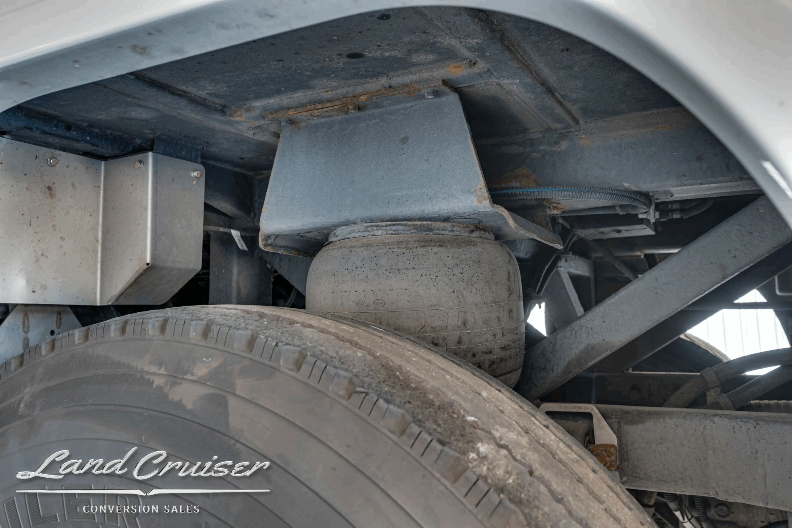 Air-suspension bag and shock absorber above wheel.