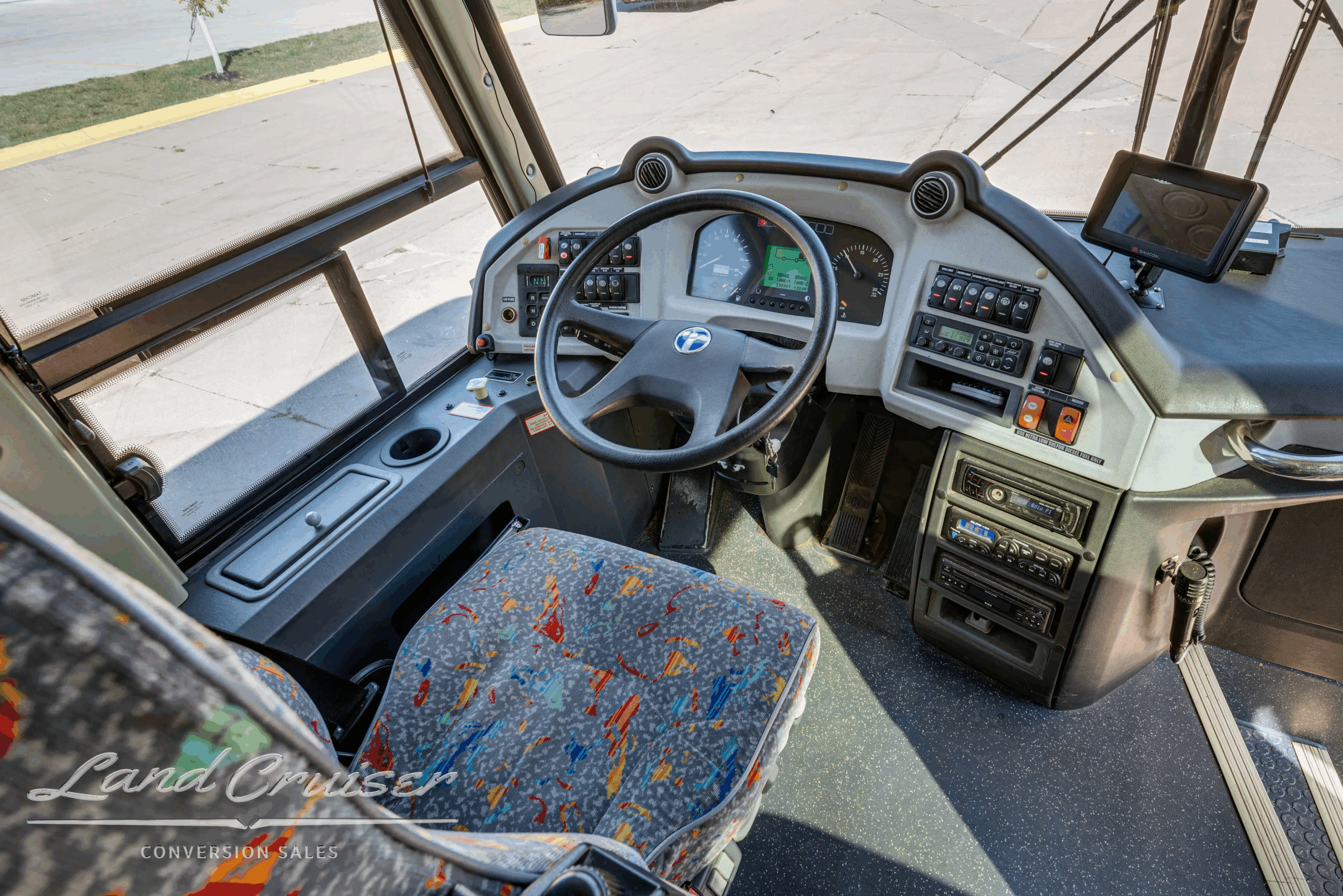Driver cockpit with steering wheel and controls.