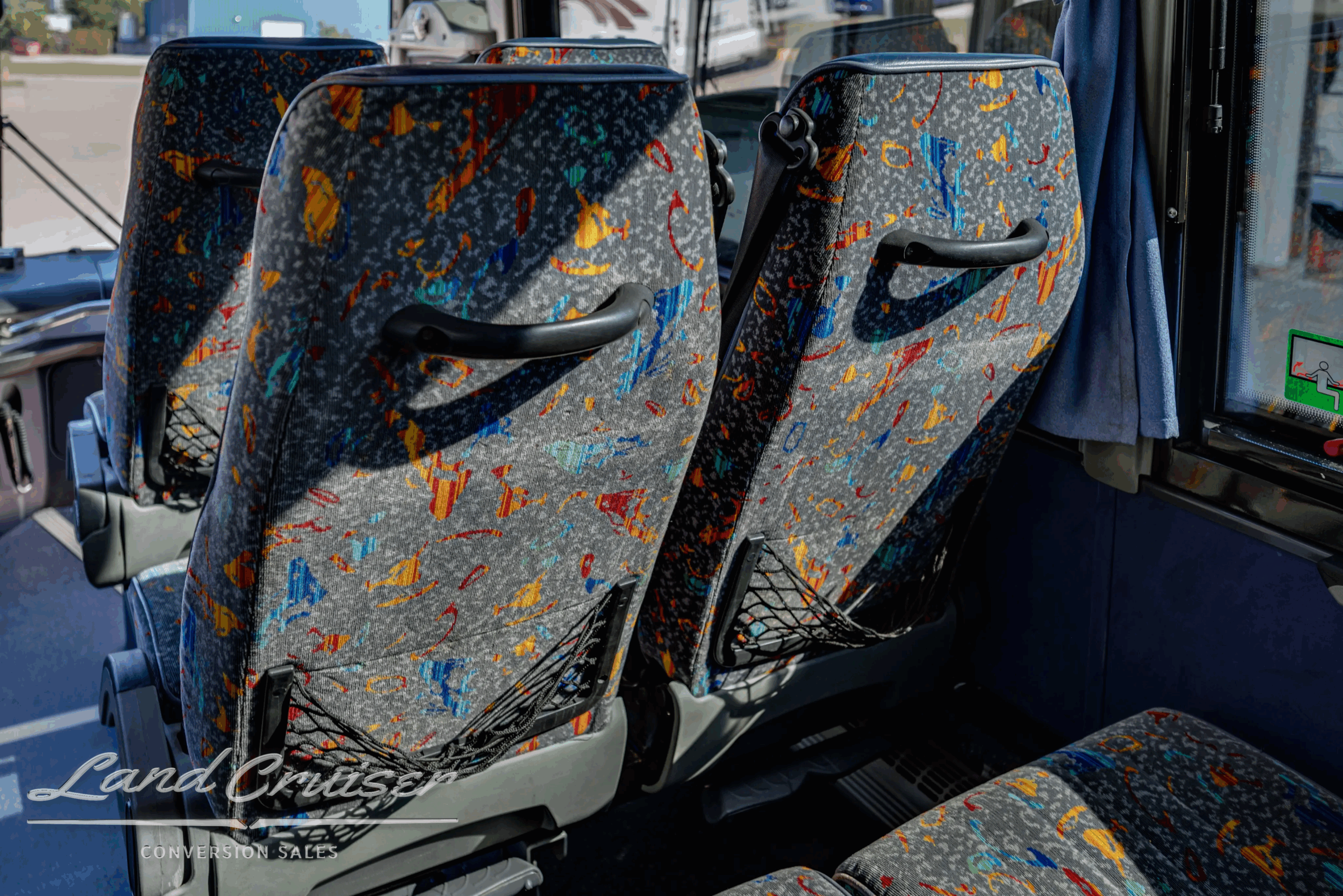 Close-up of patterned passenger seats and armrests.