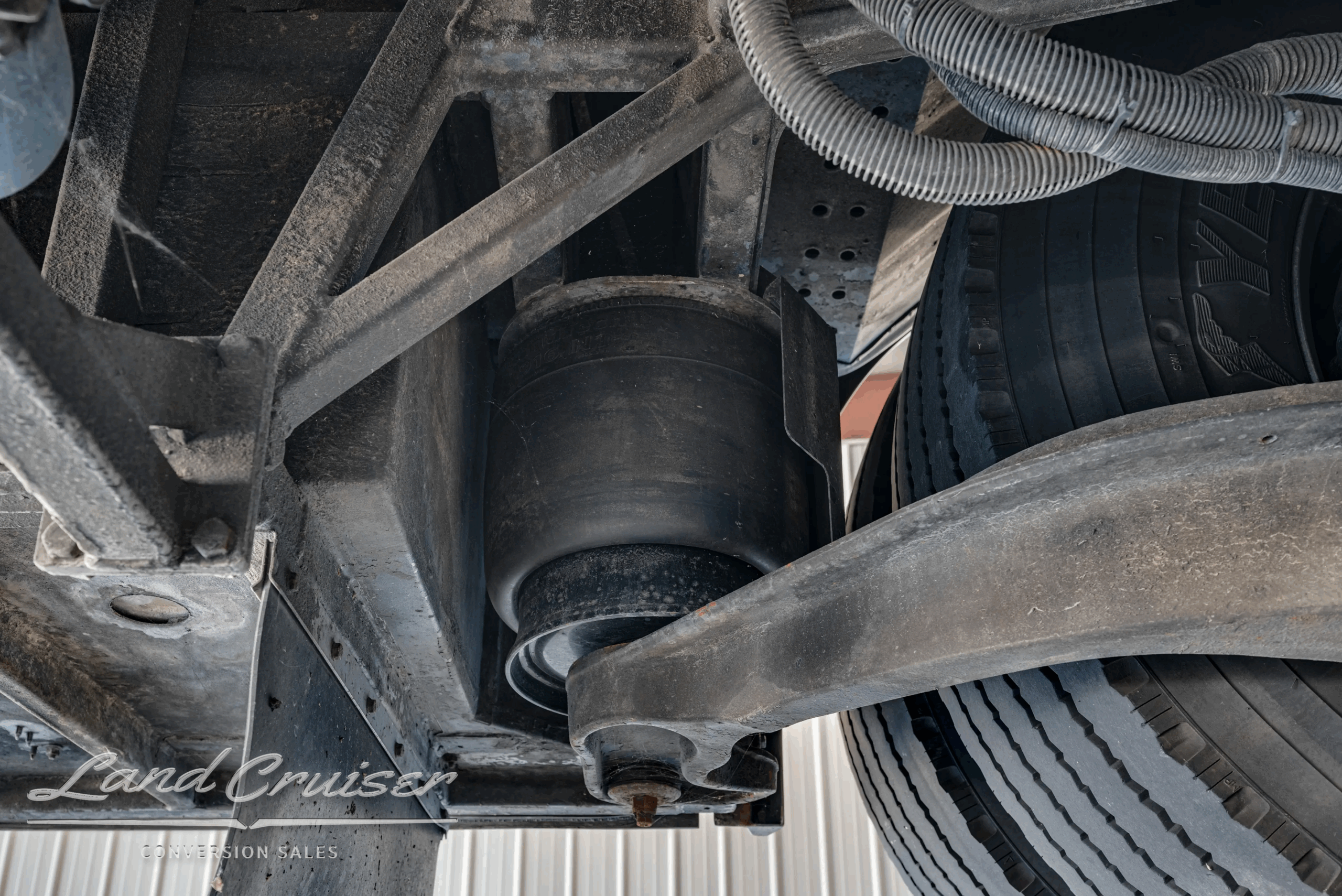 Air-suspension spring above axle, wheel-well view.