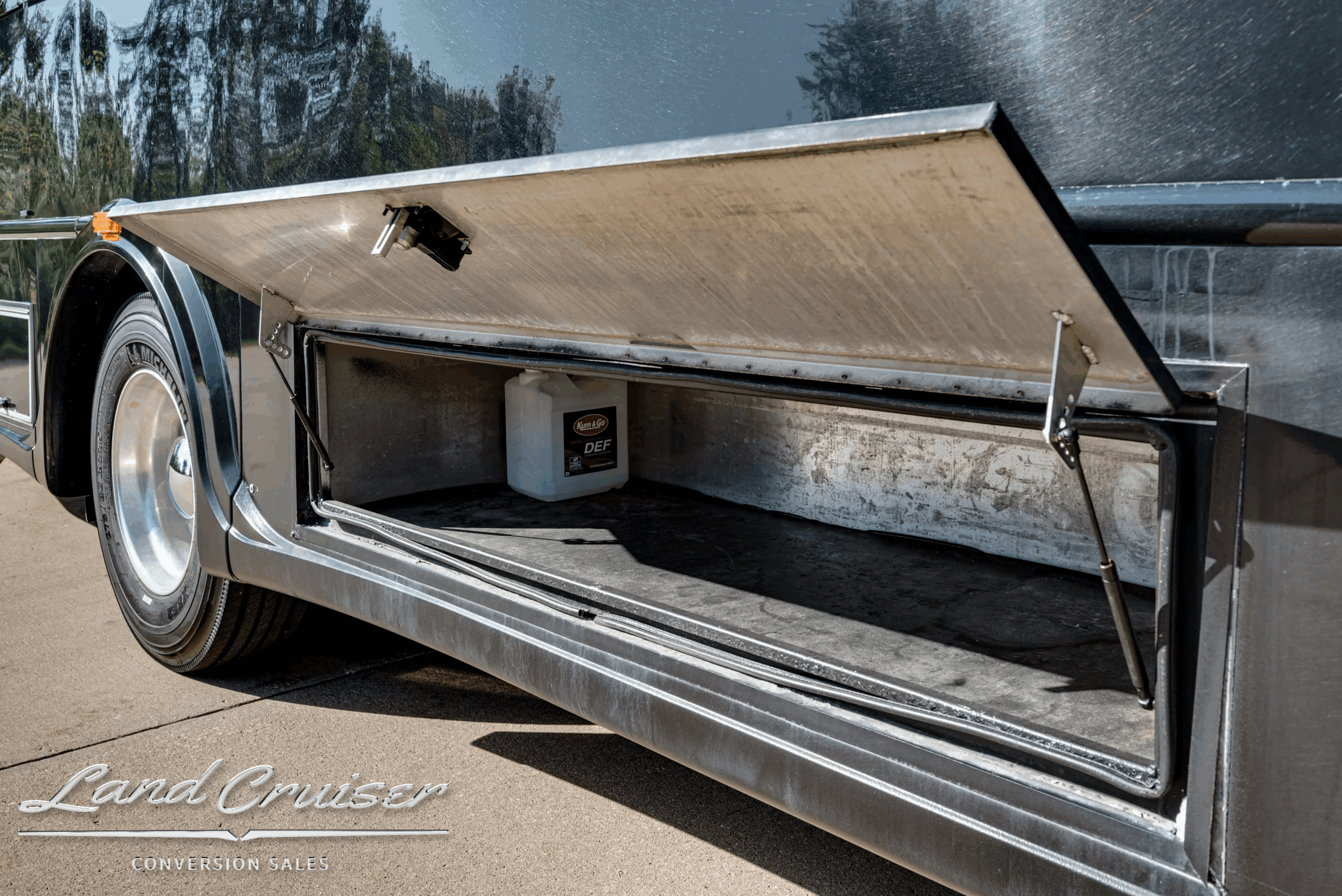 Exterior luggage/storage bay open on the passenger-side lower body.