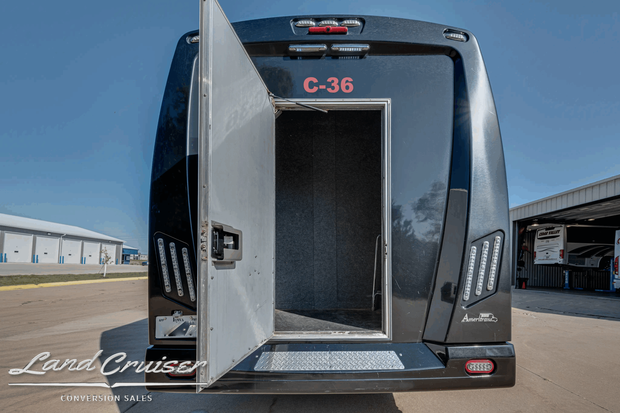 Passenger door open with entry steps into cabin on the 32-passenger bus.