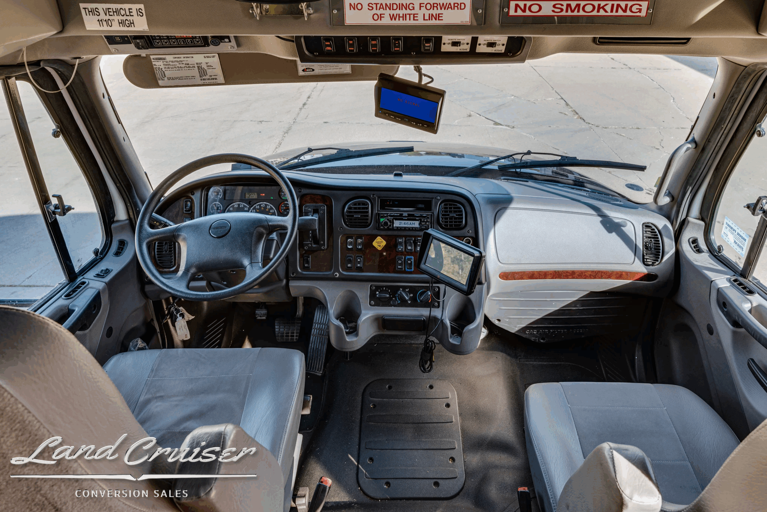Driver cockpit and dashboard with steering wheel and 7-inch monitor.