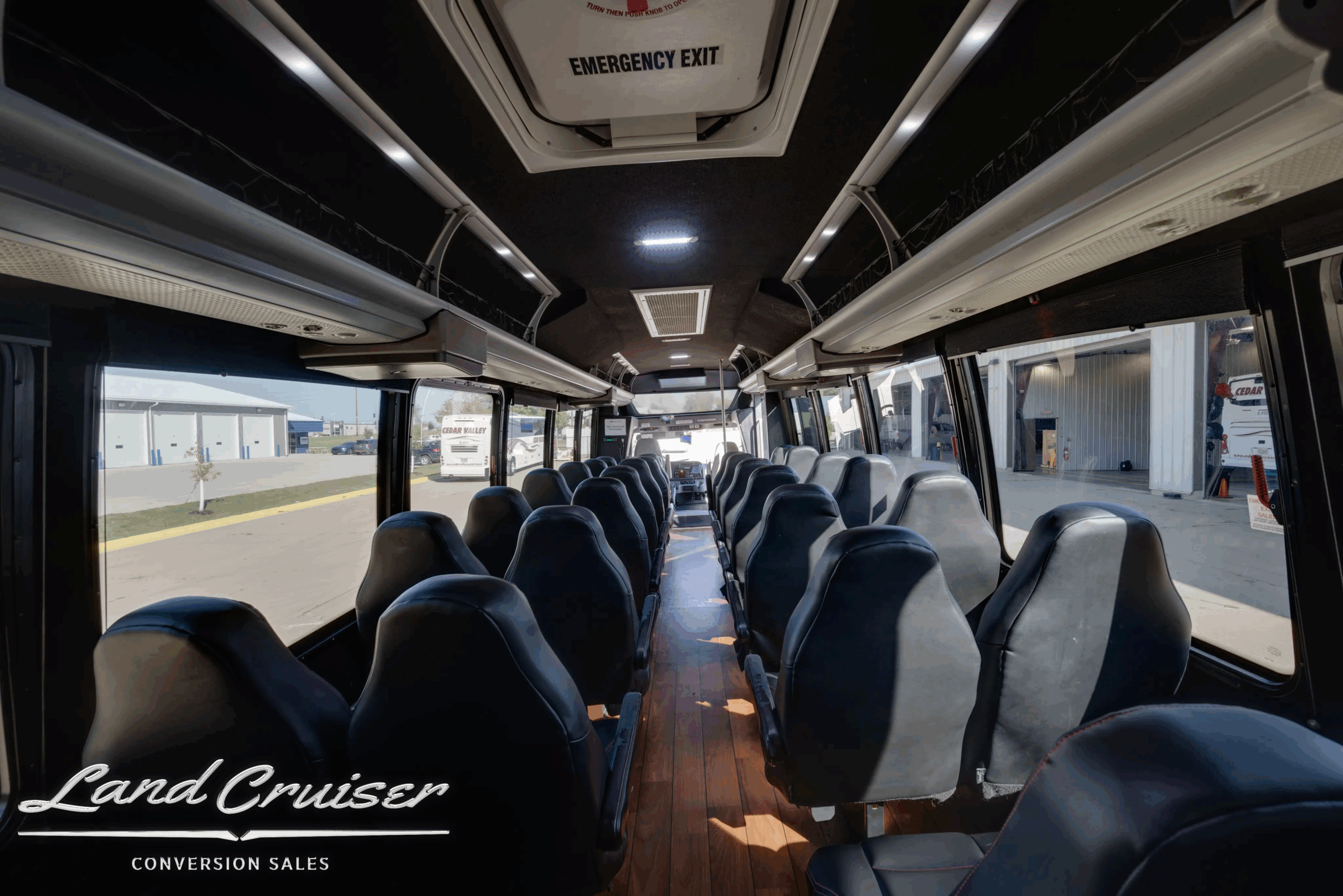 Center aisle view of the 32-passenger cabin with overhead lighting.